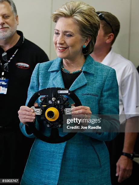 Democratic presidential hopeful U.S. Senator Hillary Clinton holds the steering wheel for the Indy race car of Sarah Fisher as she visits the...