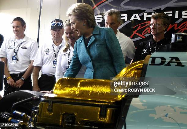 Democratic presidential hopeful New York Senator Hillary Clinton touches the back tire of the race car of Sarah Fisher during a campaign stop at the...