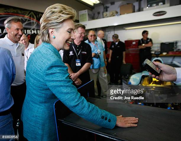 Democratic presidential hopeful U.S. Senator Hillary Clinton rubs the tail wing of race car driver Sarah Fisher's Indy race car for good luck at the...