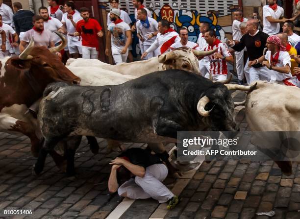 Cebada Gago's fighting bulls jump over a runner on the first day of the San Fermin bull run festival in Pamplona, northern Spain on July 7, 2017 Each...