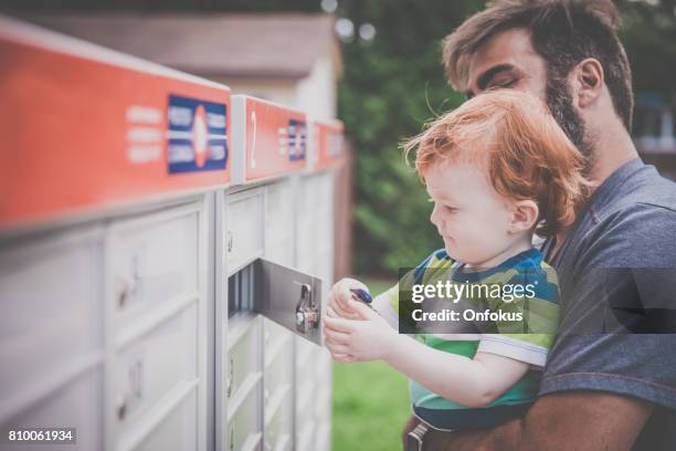 baby boy een postbus te openen met bovenliggende - openbare brievenbus stockfoto's en -beelden