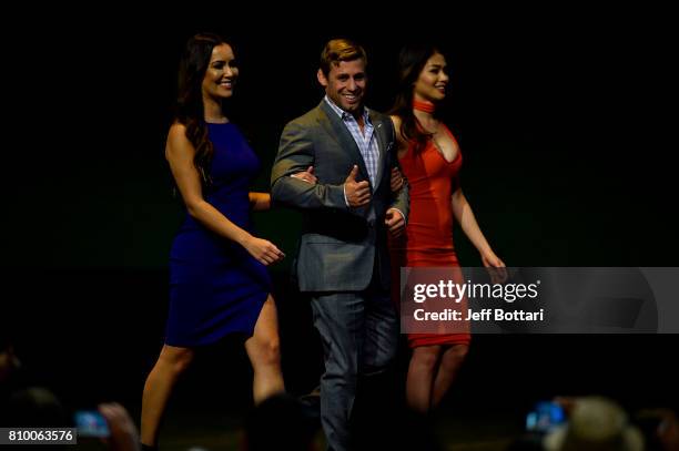 Urijah Faber walks onstage with UFC Octagon Girls Luciana Andrade and Red Dela Cruz during the UFC Hall of Fame 2017 Induction Ceremony at the Park...