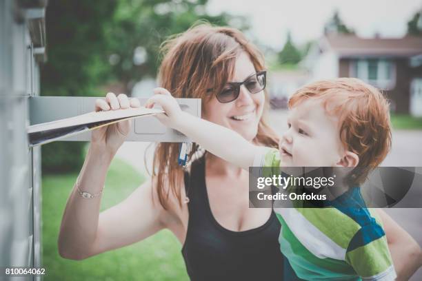 baby boy een postbus te openen met bovenliggende - openbare brievenbus stockfoto's en -beelden