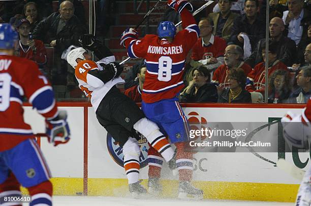 Vaclav Prospal of the Philadelphia Flyers is checked against the boards by Michael Komisarek of the Montreal Canadiens during Game Five of the...