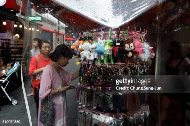 Shoppers look at products at the Myeongdong shopping district on July 7, 2017 in Seoul, South Korea. The U.S. Said that it will use military force if...