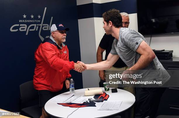 Washington Capitals head coach Barry Trotz shakes hands with with defensive prospect Connor Hobbs after a meeting at the end of the Washington...