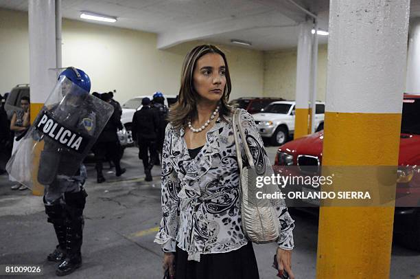 Riot policemen stand guard as Congress member Lorena Herrera departs Congress on May 6, 2008 in Tegucigalpa. An angry group of students threw stones...