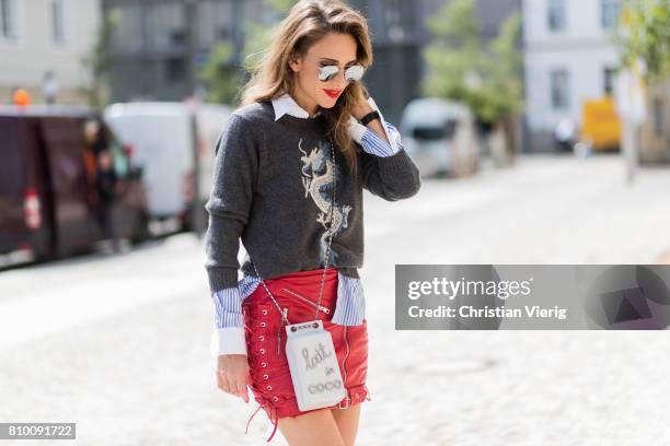 Alexandra Lapp wearing a cashmere pullover with a Dragon from Heartbreaker in cashmere, a grey cashmere scarf by Heartbreaker, a blue-white striped...