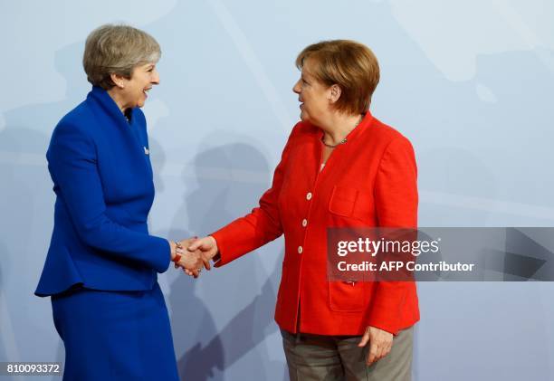 German Chancellor Angela Merkel welcomes Britain's Prime Minister Theresa May as she arrives to attend the G20 summit in Hamburg, northern Germany,...