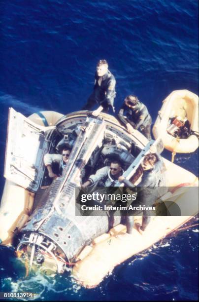 Elevated view of American astronauts David Scott and Neil Armstrong as they sit inside NASA's Gemini VIII space capsule as it floats in the Pacific...