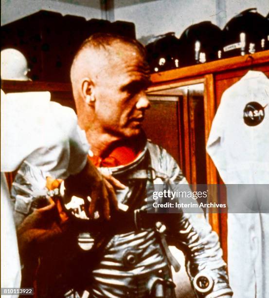 View of American astronaut John Glenn as he is helped into his spacesuit in preparation for NASA's Mercury Friendship 7 earth orbit mission, Cape...