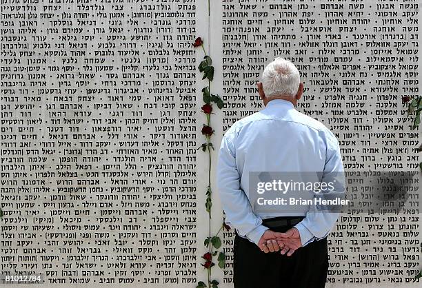 Man reads the names of fallen soldiers inscribed on a memorial wall at the Israeli army's Armoured Corps' Memorial in Latrun on Memorial Day, May 7,...