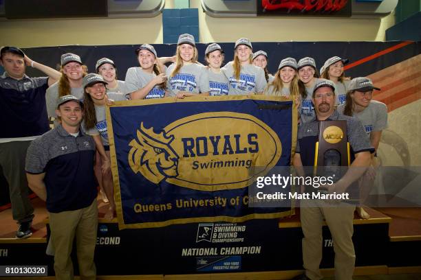 The Queens University team receives their first place trophy during the Division II Men's and Women's Swimming & Diving Championship held at the...