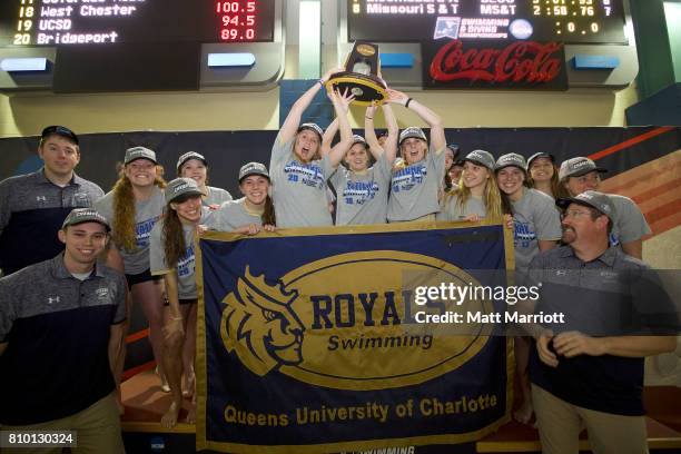 The Queens University team receives their first place trophy during the Division II Men's and Women's Swimming & Diving Championship held at the...