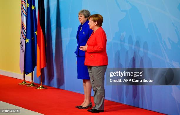 German Chancellor Angela Merkel welcomes Britain's Prime Minister Theresa May as she arrives to attend the G20 summit in Hamburg, northern Germany,...