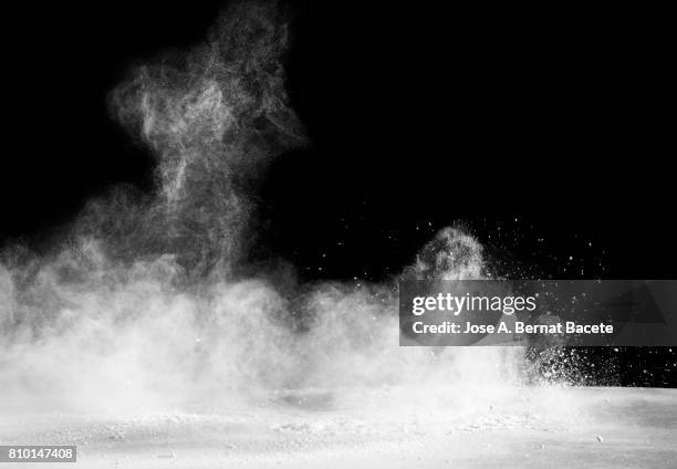 explosion of a cloud of powder of particles of color white and a black background - dampf stock-fotos und bilder