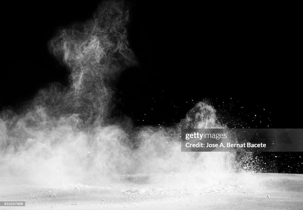 Explosion of a cloud of powder of particles of color white and a black background