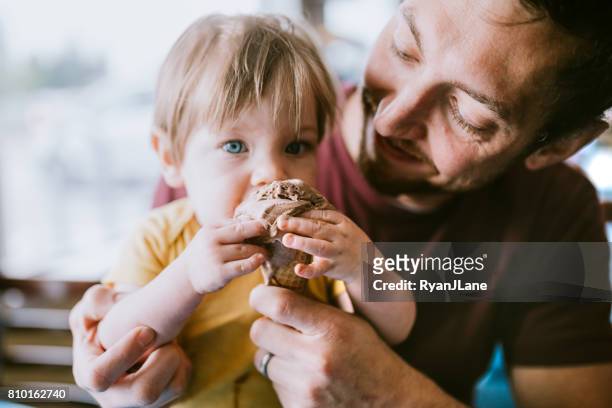 vater fütterung baby-eiscreme-kegel - sharing chocolate stock-fotos und bilder