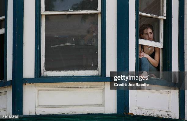 Women listens from her window as Democratic presidential hopeful U.S. Senator Hillary Clinton speaks during a campaign event at Shepherd University...