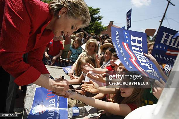 Democratic presidential hopeful New York Senator Hillary Rodham Clinton signs the hands of young girls at a campaign event outside McMurran Hall at...