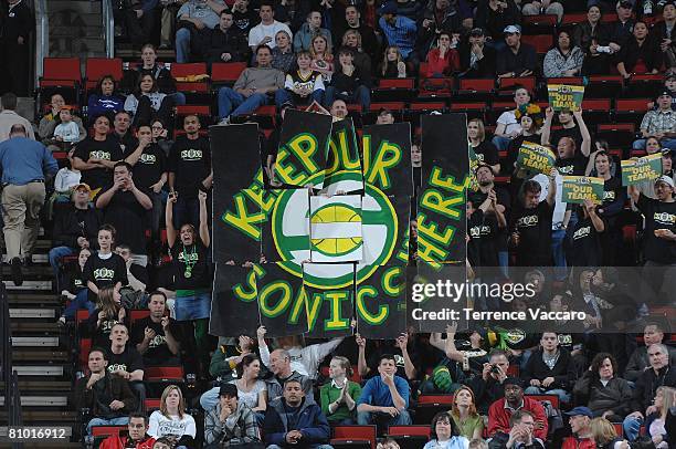 Seattle SuperSonics fans hold up signs in support of keeping the SuperSonics franchise in Seattle for the upcoming season during the game against the...