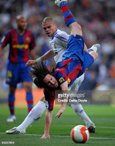 Lionel Messi of Barcelona falls over Pepe of Real Madrid during the La Liga match between Real Madrid and Barcelona at the Santiago Bernabeu stadium...