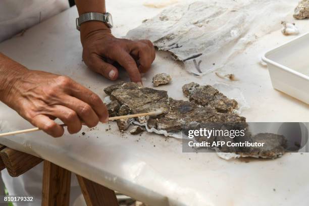 An archaeologist works onto archeological finds in the Archaeological area of Santa Croce in Gerusalemme, in the new Domus Costantiniane, three...