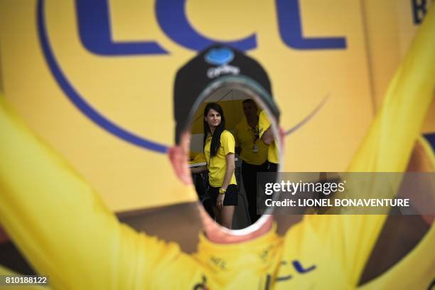 Woman is seen through shows a life-sized silhouette of the overall leader's yellow jersey with a hole for the head to be photographed through, at the...