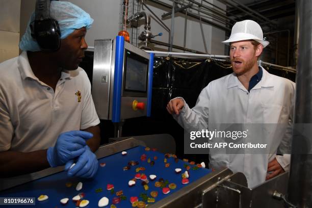 Britain's Prince Harry talks to an employee during his visit to the Haribo sweet factory in Leeds, Yorkshire on July 7 the second day of his two-day...