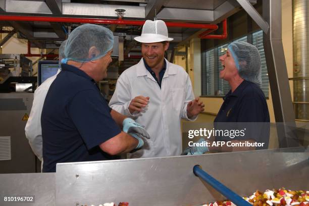 Britain's Prince Harry talks to emplyees during his visit to the Haribo sweet factory in Leeds, Yorkshire on July 7 the second day of his two-day...