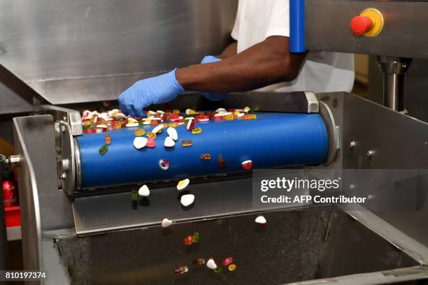 Sweets roll off the production lion during the vist of Britain's Prince Harry to the Haribo sweet factory in Leeds, Yorkshire on July 7 the second...