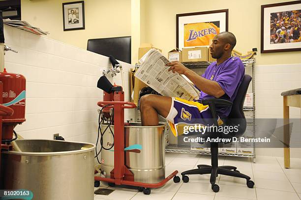 Kobe Bryant of the Los Angeles Lakers reads the newspaper while soaking his feet in the whirlpool before taking on the Utah Jazz in Game Two of the...