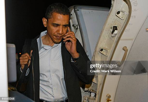 Democratic presidential hopeful Sen. Barack Obama talks on his cell phone as he boards his campaign plane at Midway Airport en-route to Washington...