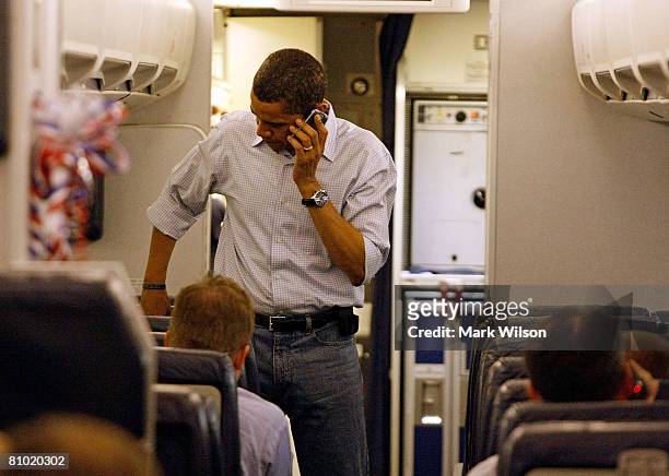Democratic presidential hopeful Sen. Barack Obama talks on his cell phone as he boards his campaign plane at Midway Airport en-route to Washington...