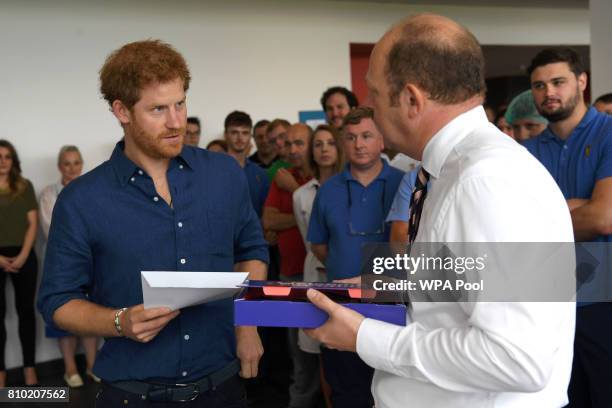 Britain's Prince Harry is presented with a specially-made box of sweets called 'Harry Mix' during his visit to the Haribo sweet factory during an...