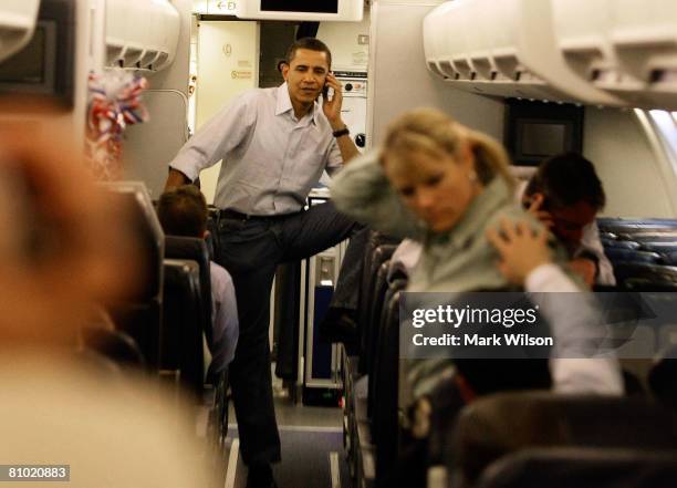 Democratic presidential hopeful Sen. Barack Obama talks on his cell phone as he boards his campaign plane at Midway Airport en-route to Washington...