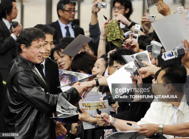 Actor Sylvester Stallone greets fans upon his arrival for the premiere of his latest movie, "Rambo" in Tokyo on May 8, 2008. "Rambo" will roadshow in...