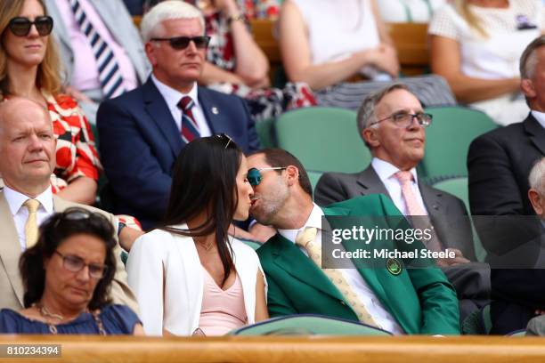 Golfer Sergio Garcia and fiancee Angela Akins share a kiss in the centre court royal box on day five of the Wimbledon Lawn Tennis Championships at...