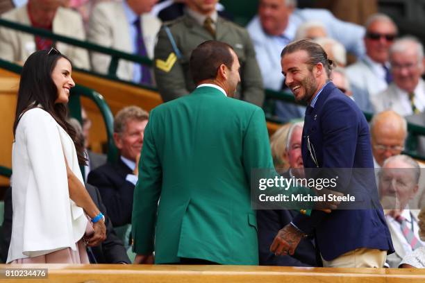 Golfer Sergio Garcia and David Beckham greet each other as Angela Akins looks on from the centre court royal box on day five of the Wimbledon Lawn...