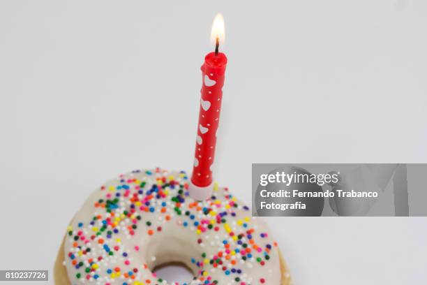 celebrating the anniversary with colorful donut - one year anniversary stock-fotos und bilder