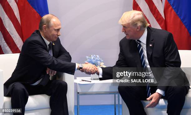 President Donald Trump and Russia's President Vladimir Putin shake hands during a meeting on the sidelines of the G20 Summit in Hamburg, Germany, on...