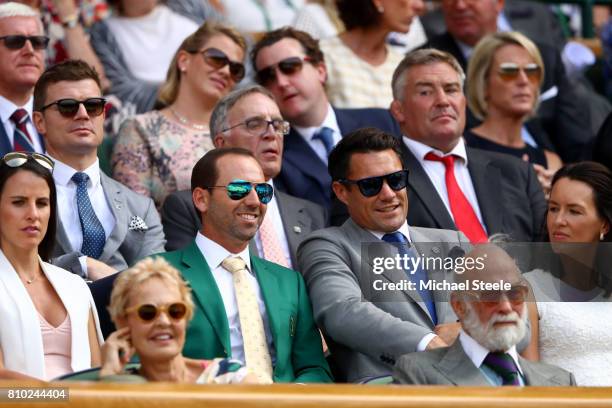 Golfer Sergio Garcia, his fiancee Angela Akins, Dan Carter and wife Honor Carter look on from the centre court royal box on day five of the Wimbledon...