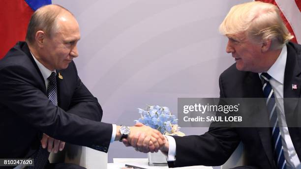 President Donald Trump and Russia's President Vladimir Putin shake hands during a meeting on the sidelines of the G20 Summit in Hamburg, Germany, on...