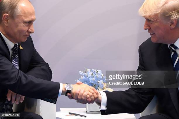 President Donald Trump and Russia's President Vladimir Putin shake hands during a meeting on the sidelines of the G20 Summit in Hamburg, Germany, on...