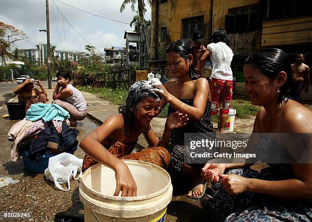 Women use a bucket to cleanse themselves on May 8, 2008 in downtown Yangon, Myanmar. It has been estimated that more than 100,000 people were killed...