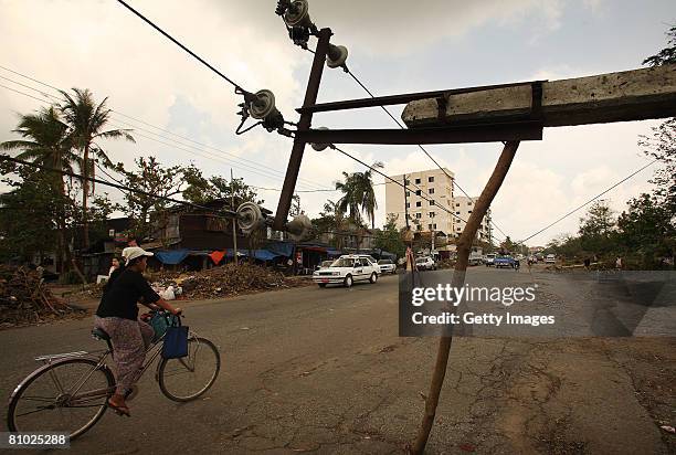 Man cycles past a fallen electric poll on May 8, 2008 in Yangon, Myanmar. It has been estimated that more than 100,000 people were killed by Cyclone...