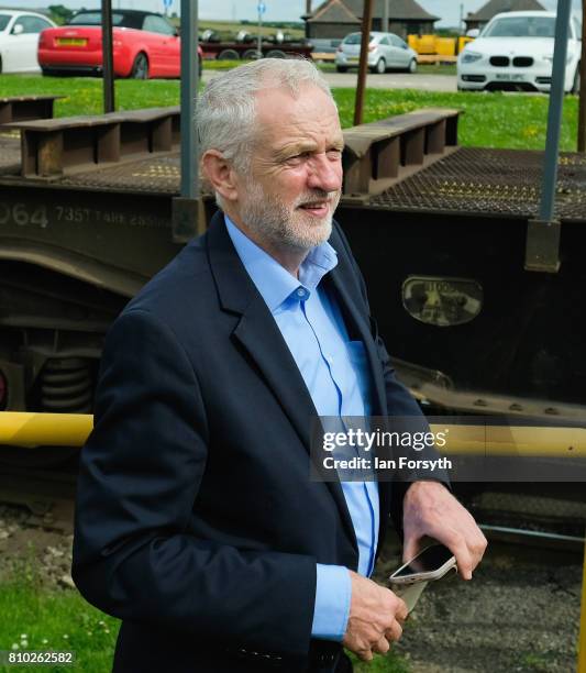 Labour Party leader Jeremy Corbyn waits to cross a railway line during a visit to the British Steel manufacturing site to tour the facility and meet...