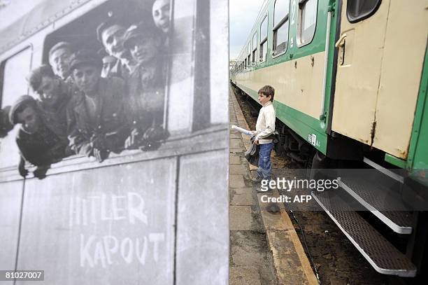 Young passenger of the 'Train of Remembrance' stands by a photograph taken at the end of World War II as he takes part in a March of Silence on the...