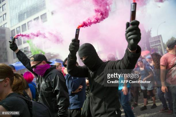 Protesters light flares on July 7, 2017 in Hamburg, northern Germany, where leaders of the world's top economies gather for a G20 summit. Protesters...