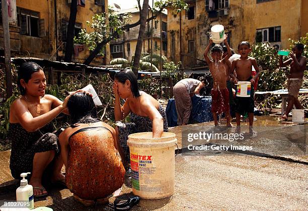 Women and children cleanse themselves with water on May 8, 2008 in downtown Yangon, Myanmar. It has been estimated that more than 100,000 people were...